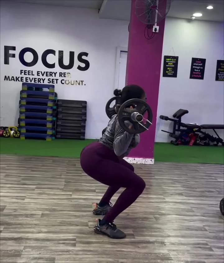 Woman lifting weights with focus and confidence